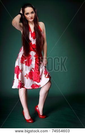 Young Woman In Summer Flowery Dress On Green