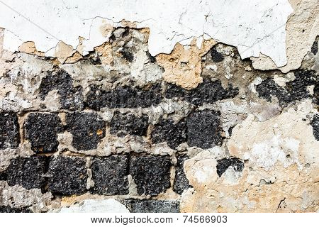 Old Brick Wall With The Damaged Plaster