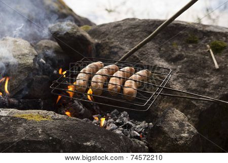 Sausages cooking over a fire