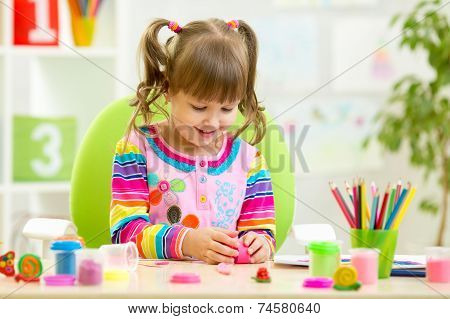 child girl playing with colorful clay