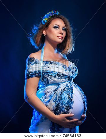 Young pregnant woman in fashionable dress