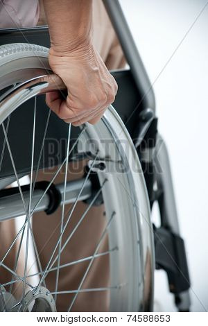 Hand of senior woman on wheelchair