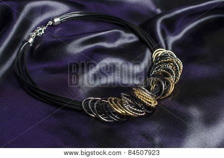Necklace With Rings On A Silk Background