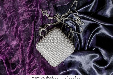 White Clutch Inlaid Diamonds On Silk Background