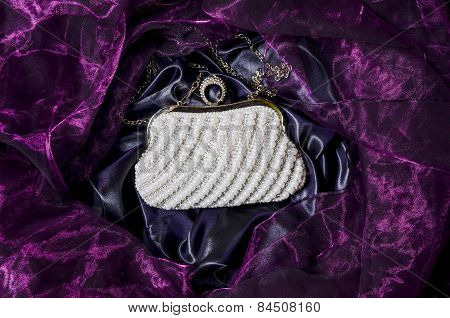 Clutch With Pearls On A Silk Background