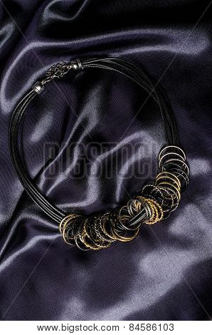 Necklace With Rings On A Silk Background
