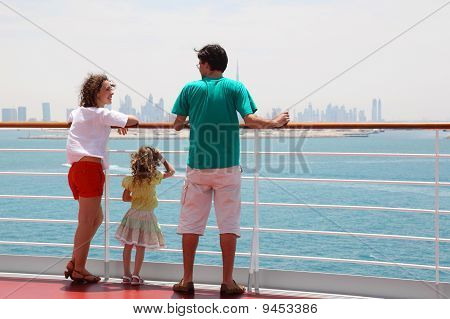 Familie med datter stående på Cruise Liner dækket, udsigten fra bagsiden, by horisonten