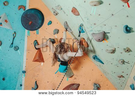 Girl In Safety Equipment Climbing In Gym