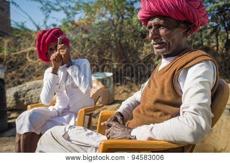 GODWAR REGION, INDIA - 13 FEBRUARY 2015: Elderly Rabari tribesman sits with neighbour who smokes chillum. Rabari or Rewari are an Indian community in the state of Gujarat.