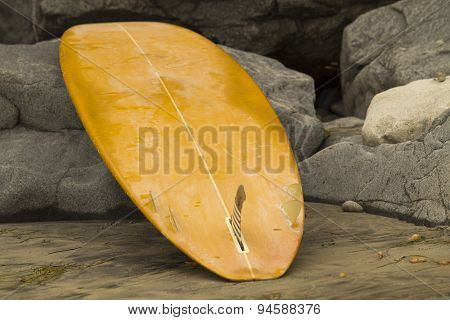 Surfboard Leaning On Rocks At Beach