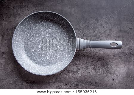 Ceramic pan on concrete kitchen board. Kitchen utensil. Empty pan.