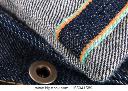 Close Up Of Jeans Fragment With Button. Denim Texture. Selvage.