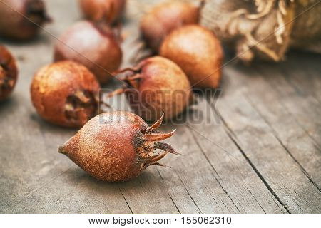 Common medlar fruit (mispel) on grey rustic wooden background. Copy space