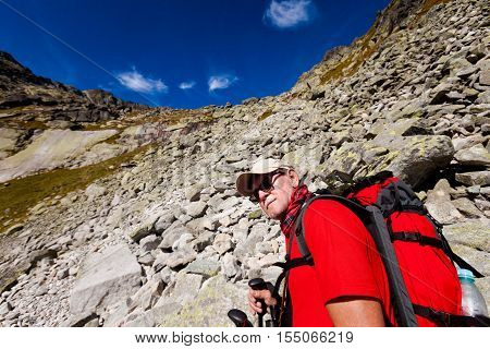Tourist trekking in Beautiful Mlynicka dolina on the way to Bystre sedlo - in slovakian high Tatra mountains. Summer panorama with great weather and blue sky