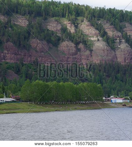 Wooded steep mountains near the river .