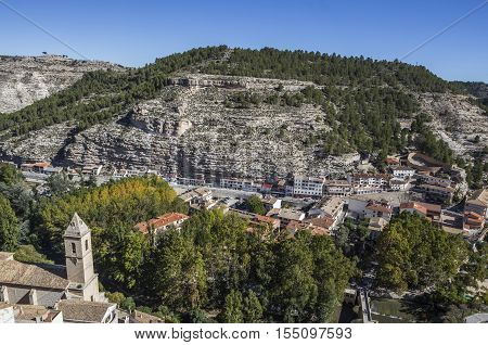 Alcala del Jucar Spain - October 29 2016: To the left the church of San Andres and to the right the roman bridge panoramic view from the castle during autumn take in Alcala of the Jucar Albacete province Spain