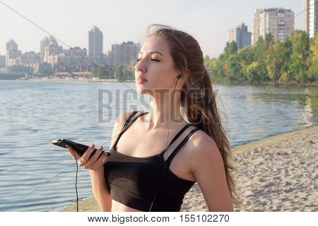 Young Girl At Coast Listening To Music On Cell Phone