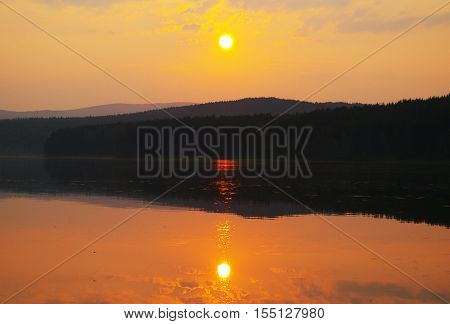 The sun in the haze over the lake.