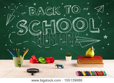 Back to school concepty with writing on blackboard and desk, apple, books, items