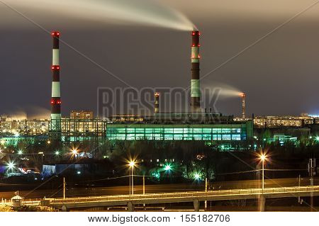 Smoke from pipes of combined heat and power plant against the background of the night sky