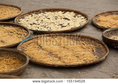 Hanoi, Vietnam May 08 2016 : workers exposed Arrowroot vermicelli - a special Vietnamese noodles are being dried the roads of village.