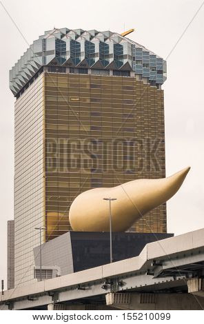 Tokyo Japan - September 28 2016: The two Asahi corporate buildings against gray rainy sky. Tallest one represents the image of a golden lager in a glass. Other is museum with flame on top. Highway in front.