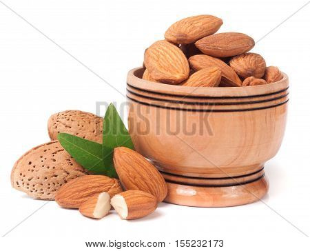 heap of almonds in their skins and peeled with leaf isolated on white background.