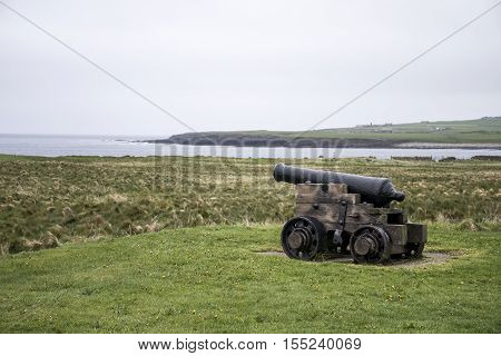 shooting cannon at Orkney coastline cliff landscape