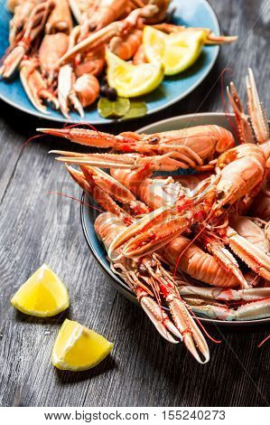 Fresh scampi served with lemon on old wooden table