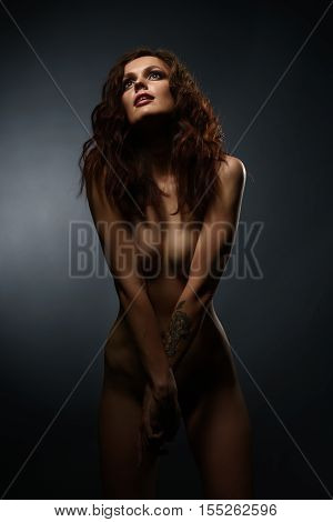 Nude. Vertical photo of skinny brunette with thin waist