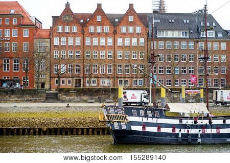 Bremen, Germany - March 23, 2016: A Ship In Front Of Historic Facades Of Houses On Embankment Of Wes
