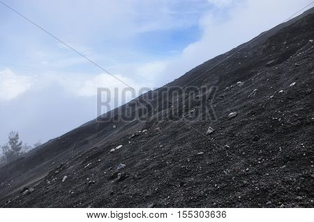 Climbing the volcano Semeru Indonesia. Crater covered with debris and slag