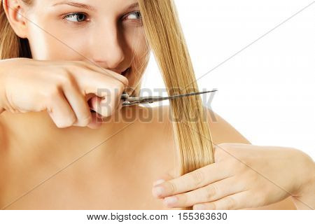 Attractive young woman is cutting her long natural hair