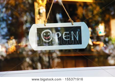 Door window sign open with smile hadwritting with chalk