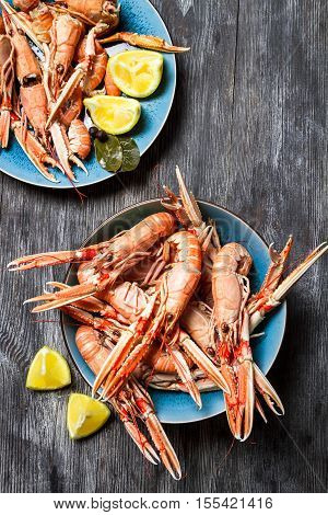 Fresh scampi served with lemon on old wooden table