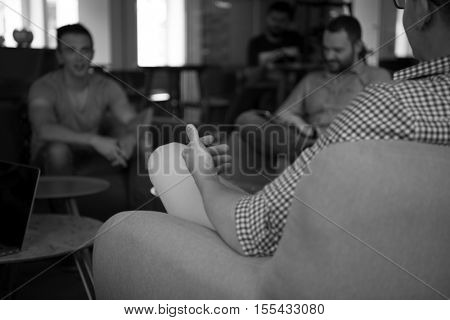 close up of male hands while working in modern office group opf people on team meeting and brainstorming in background
