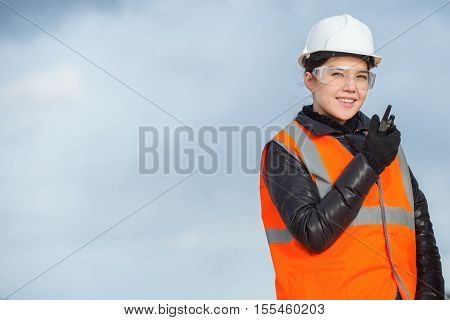 Beautiful female worker with radio at the factory