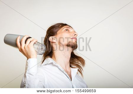Alcohol liquor drinking party relax concept. Young bartender shaking glasses. Male barman holding glass and shaker preparing mixed beverage.