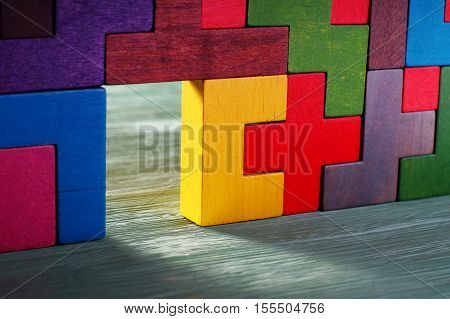 Move beyond. Glowing doorway colorful wall of wooden puzzles. Move beyond meaning or definition.