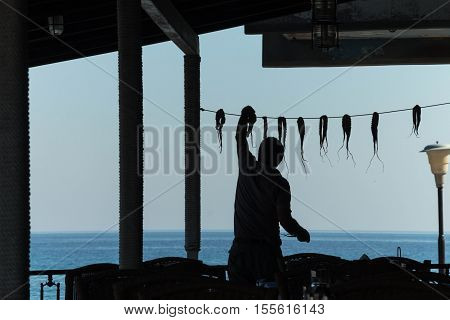 silhouette of a man weighing octopus on the background of the sea