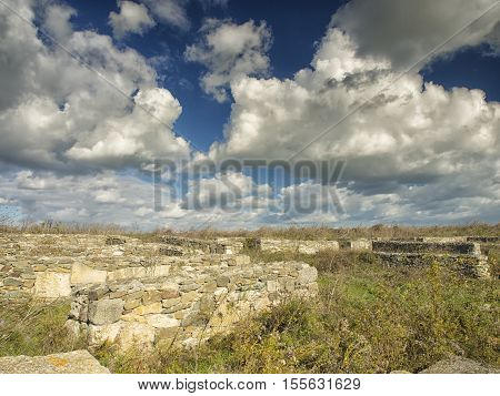 A dramatic blue sky with white clouds over the ruins of the ancient greek colony of Histria, on the shores of Black Sea. Histria is the oldest urban settlement on Romanian territory