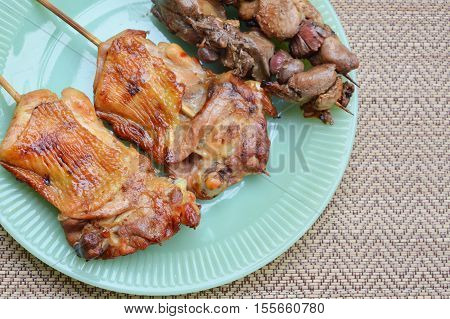 grilled chicken and entrails in wooden stick on dish