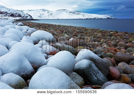 Beach with big round stones on the coast of the Barents Sea Arctic