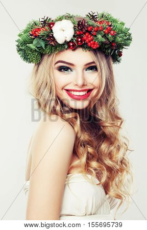 Happy Model Woman with Christmas Wreath. Beautiful Woman with Blonde Hairstyle and Makeup