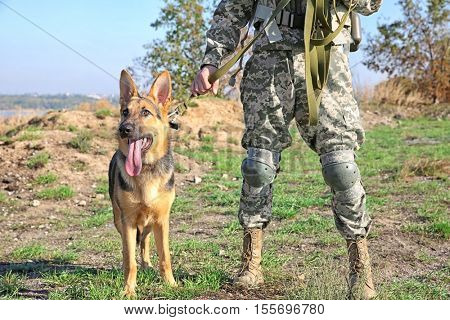 Soldier with german shepherd dog at military firing range