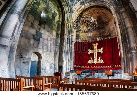 HAGHPAT ARMENIA - MARCH 25 2016: Inside a Haghpat Monastery - famous landmark in Armenia. Rows with wooden seats in front of an altar. Chandelier and beautiful religious decoration