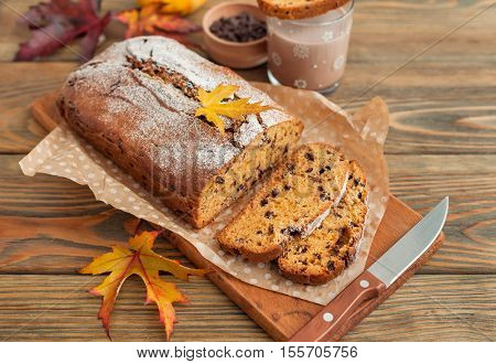 Homemade pumpkin cake with chocolate on wooden background. Autumn still life.