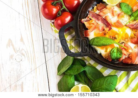 Pan Of Fried Eggs With Tomatoes, Bacon, Spinach, Lime