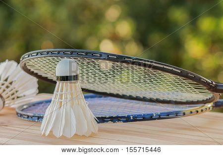shuttlecocks on racket for a badminton on wood background light green outdoor background