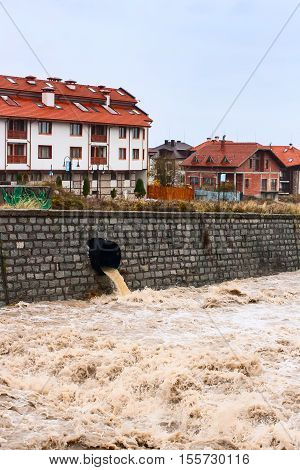 Bansko, Bulgaria - November 9, 2016: High water flow in Glazne river after heavy rains and remains of bridge carried away by the waters